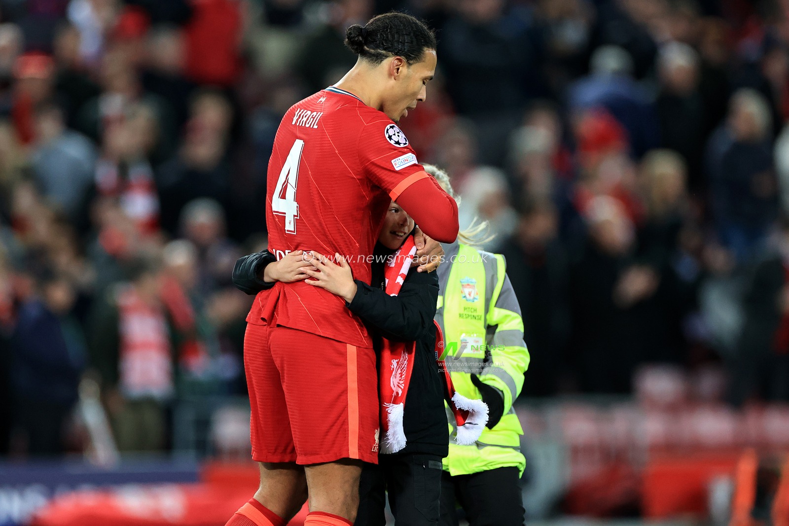 Virgil van Dijk #4 of Liverpool with a young fan