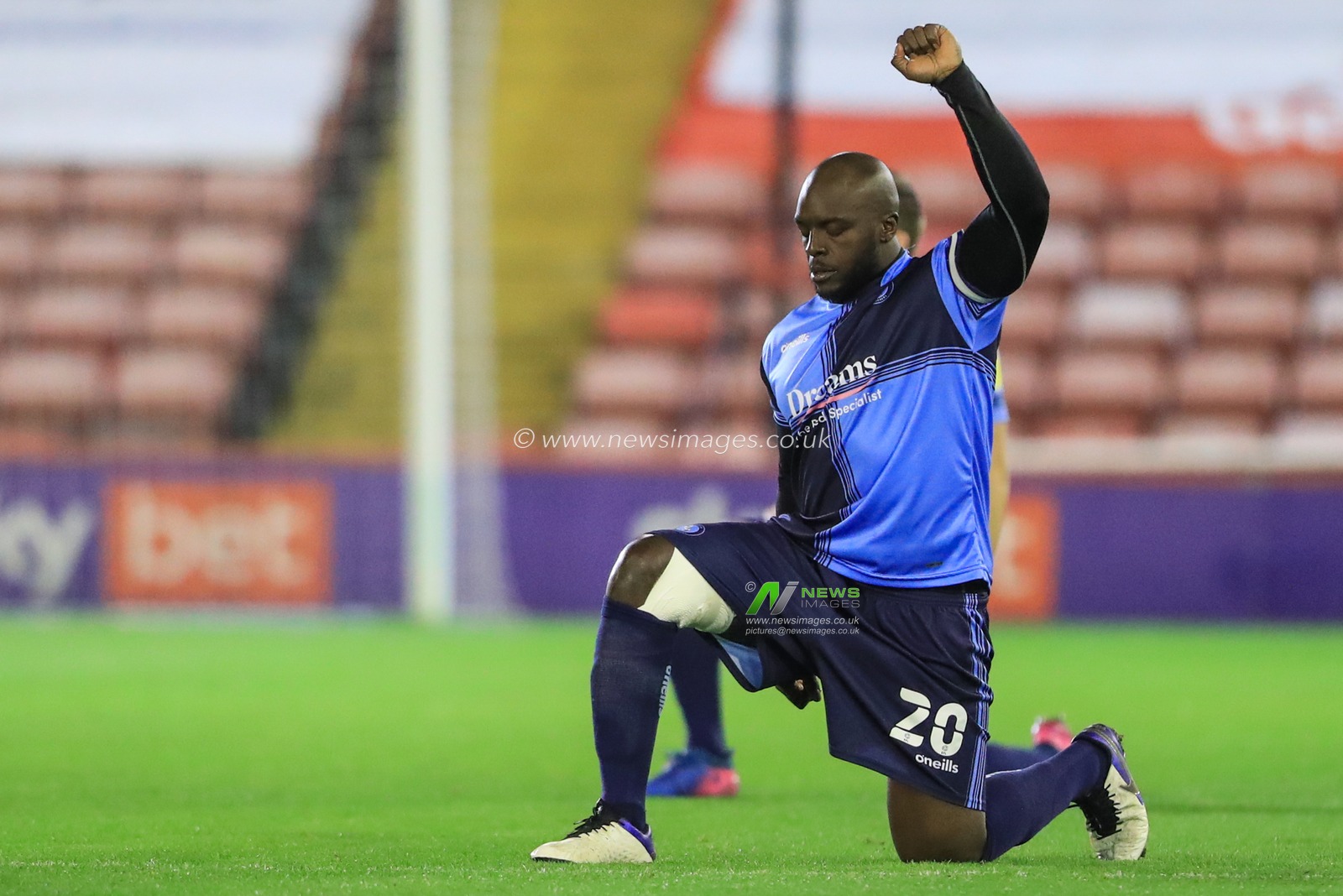 Adebayo Akinfenwa #20 of Wycombe Wanderers takes the knee before the game