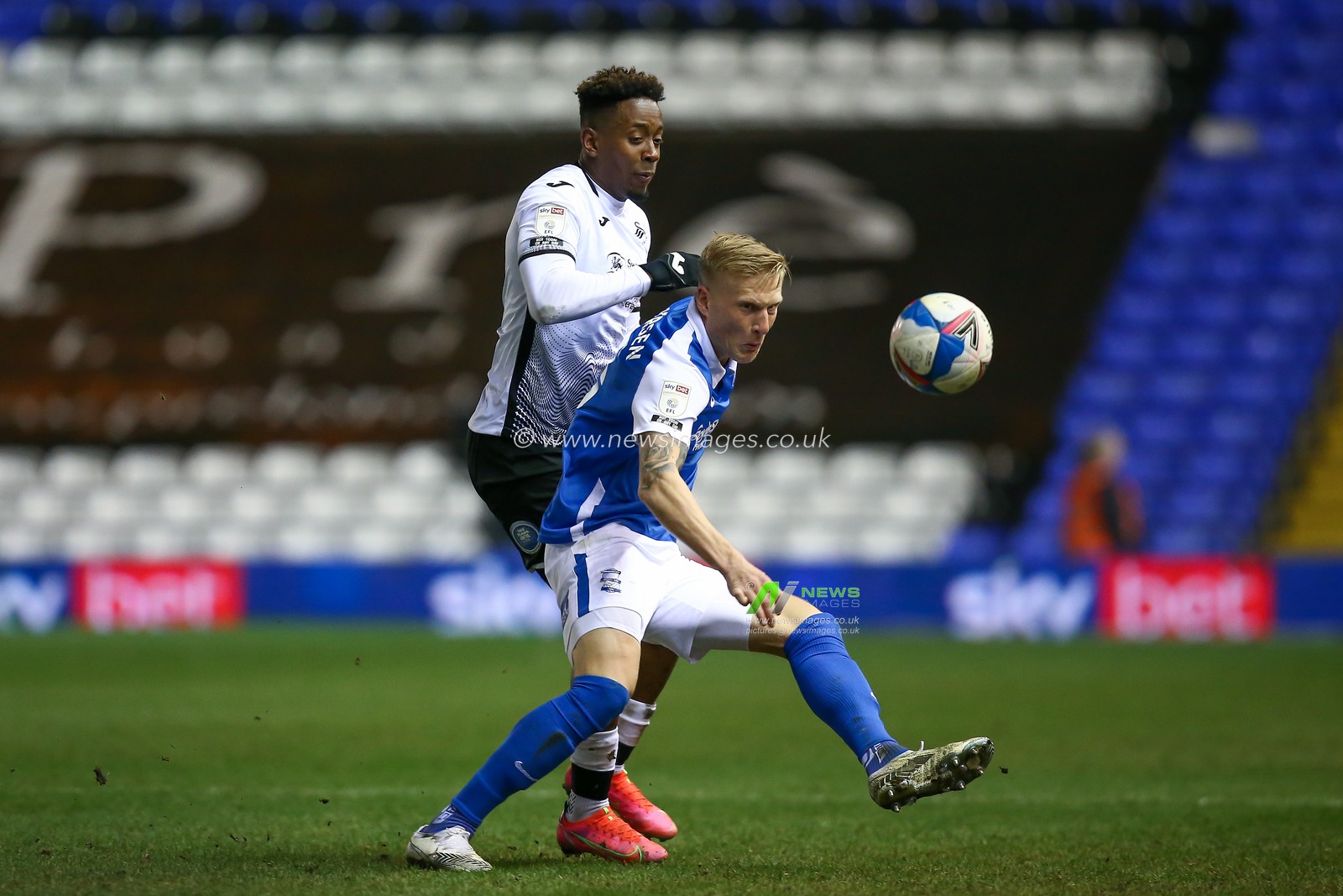 Kristian Pedersen #3 of Birmingham City holds off Jamal Lowe #9 of Swansea City