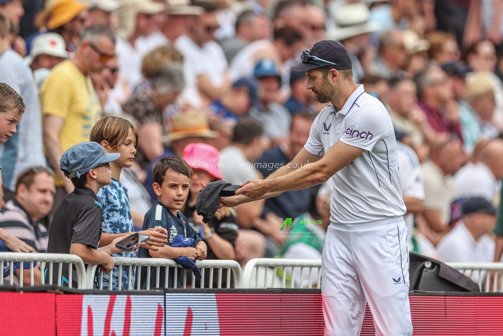 Mark Wood of England signs a hat for a young fan during the Rothesay Test Match day three England vs West Indies at Trent Bridge, Nottingham, United Kingdom, 20th July 2024

(Photo by Mark Cosgrove/News Images)