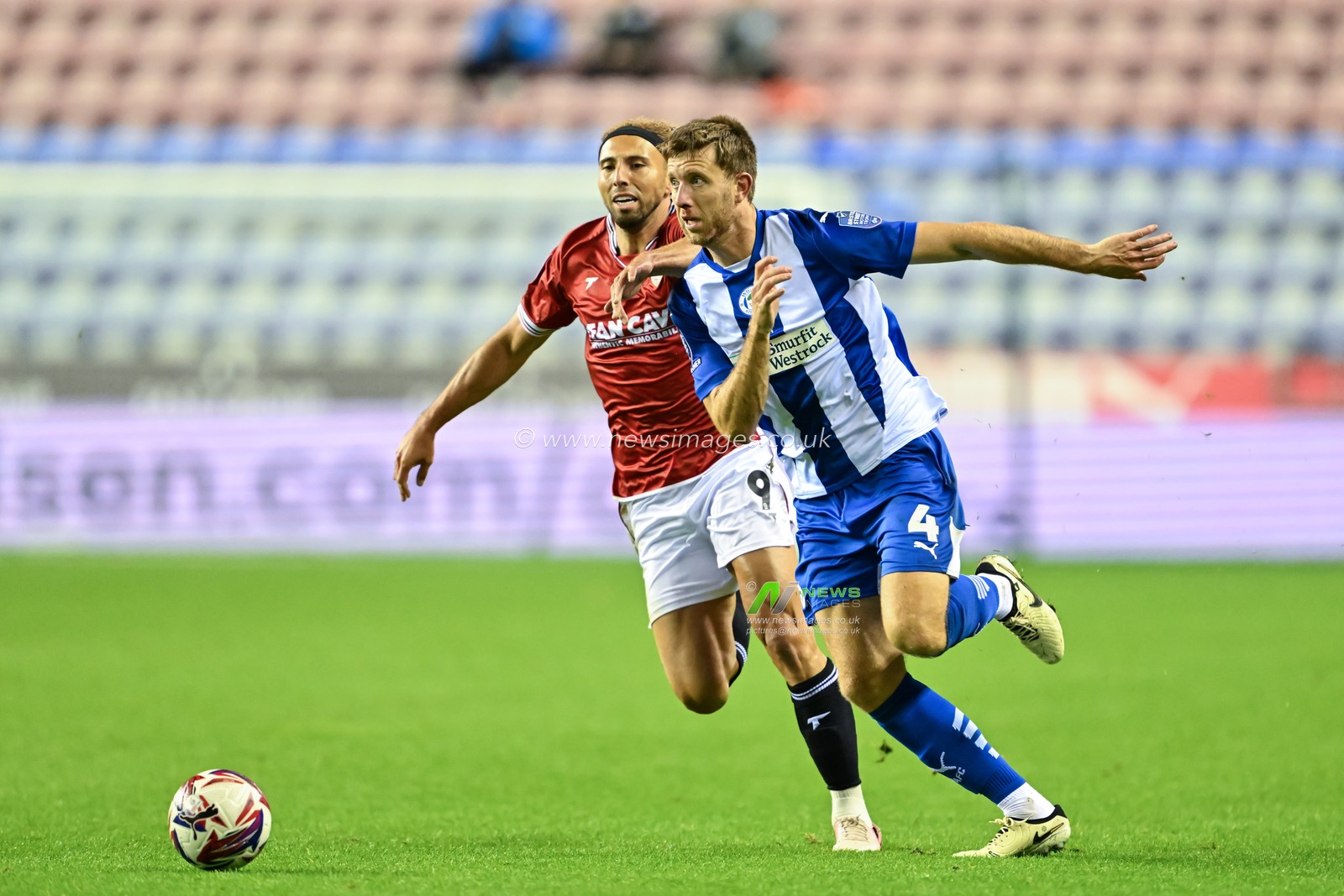 Will Aimson of Wigan Athletic holds off Hallam Hope of Morecambe as he breaks forwards with the ball during the Bristol Street Motors Trophy match Wigan Athletic vs Morecambe at DW Stadium, Wigan, United Kingdom, 3rd September 2024

(Photo by Cody Froggatt/News Images)