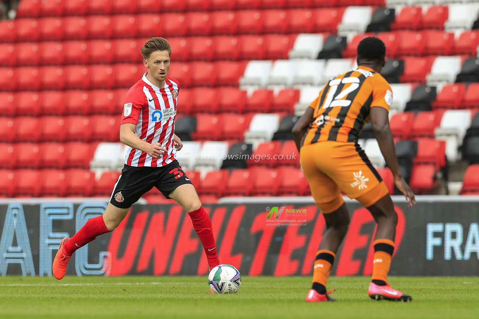 Denver Hume (33) of Sunderland in action with Josh Emmanuel (12) of Hull City watching him