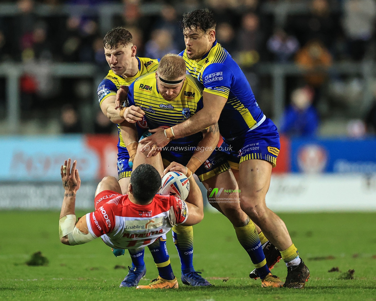 Sione Mataâ€™utia #11 of St Helens is tackled by Oliver Holmes #12 of Warrington Wolves