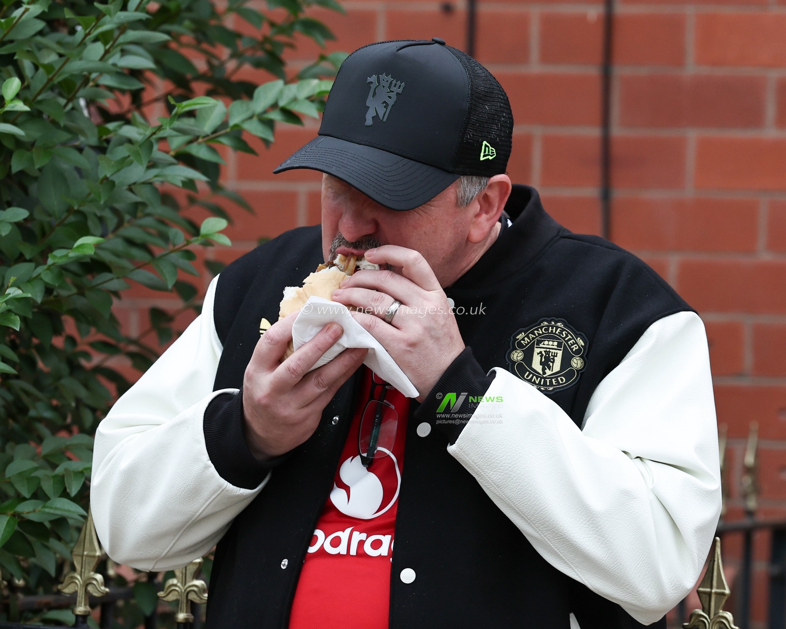 Manchester United fan having a bite to eat on their way to Old Trafford during the Premier League match Manchester United vs Burnley at Old Trafford, Manchester, United Kingdom, 30th August 2025

(Photo by Mark Cosgrove/News Images)