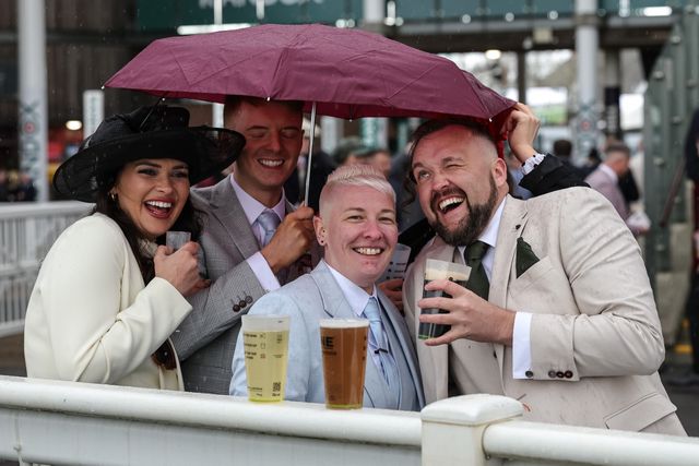 Racegoers hide under a brolly as hail pours from the sky during the 2026 Randox Grand National Day at Aintree Racecourse, Aintree, United Kingdom on 11 April 2026

(Photo by Mark Cosgrove/News Images)