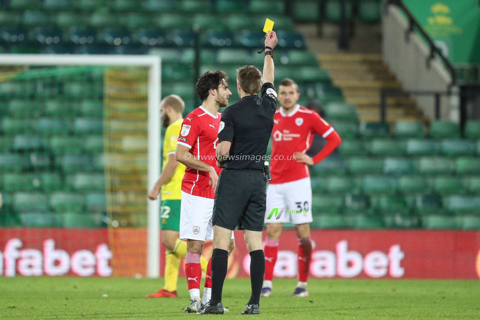 Matthew James #32 of Barnsley receives a yellow card from referee Michael Sailsbury