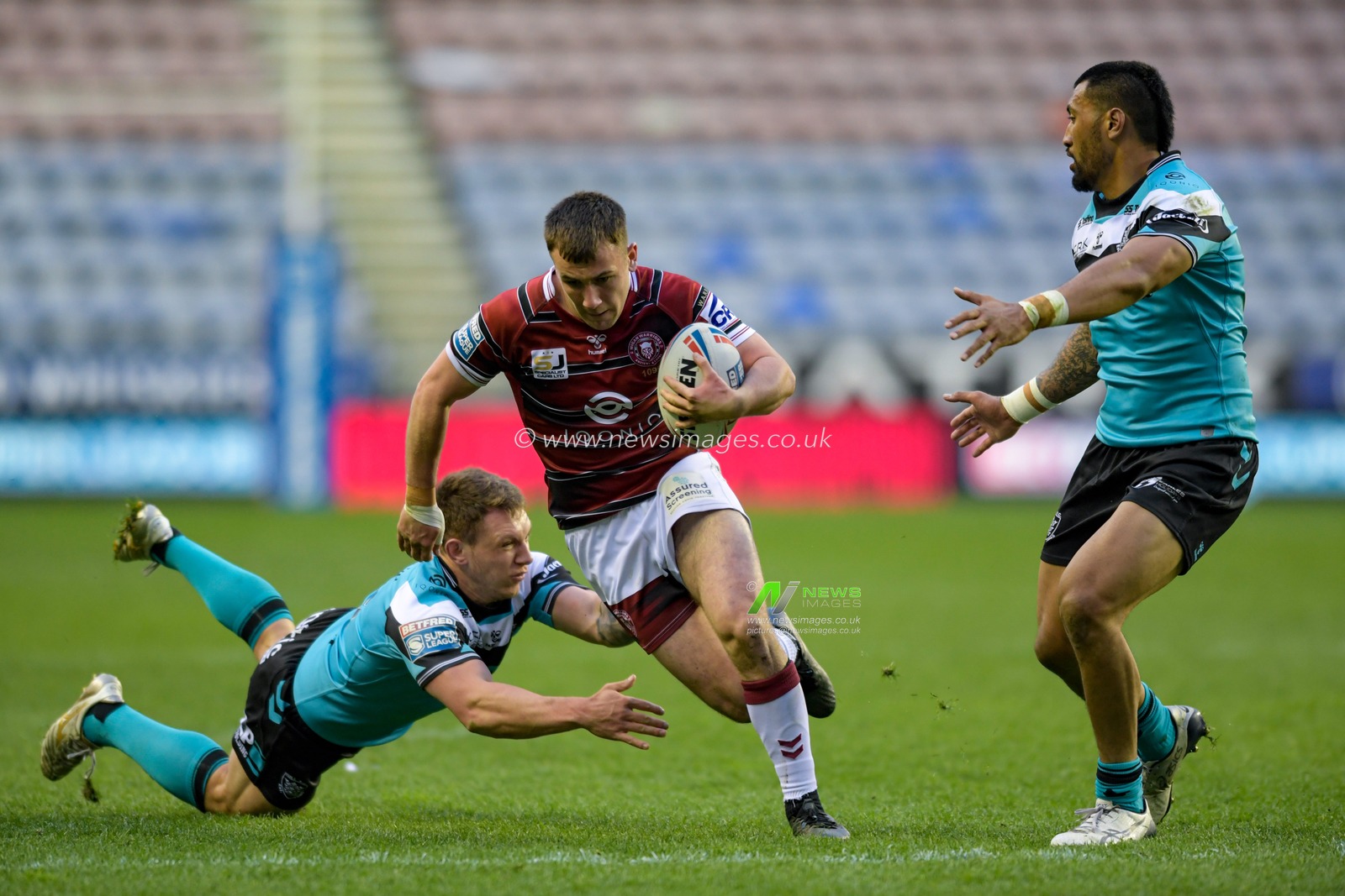Harry Smith (20) of Wigan Warriors evades the tackle attempt from Jordan Lane (16) of Hull FC