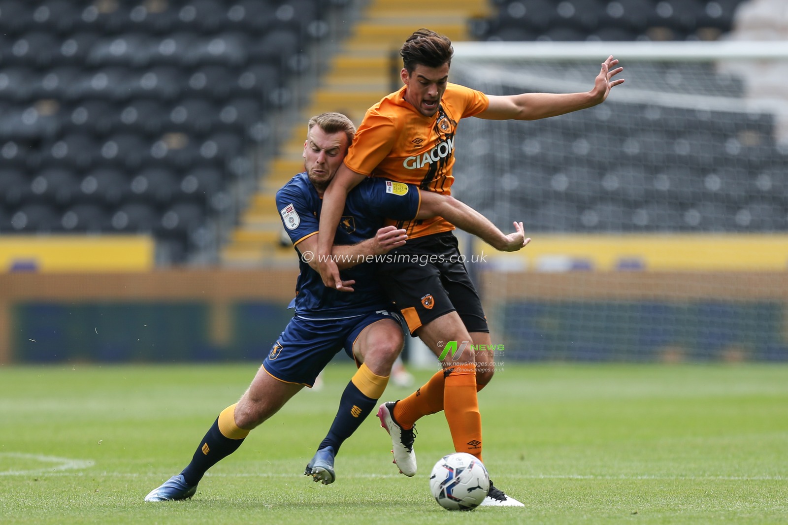 Jacob Greaves (4) of Hull City and Rhys Oates (18) of Mansfield challenge for the ball