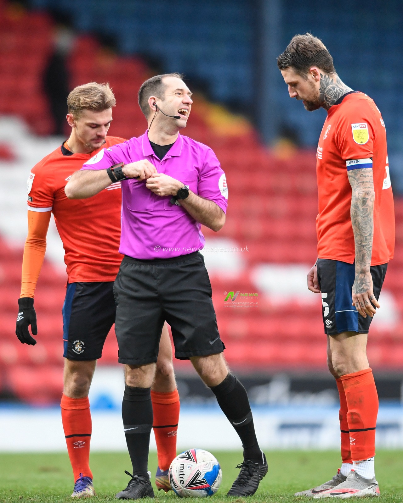 Referee Jeremy Simpson shares a joke with Sonny Bradley #5 of Luton Town