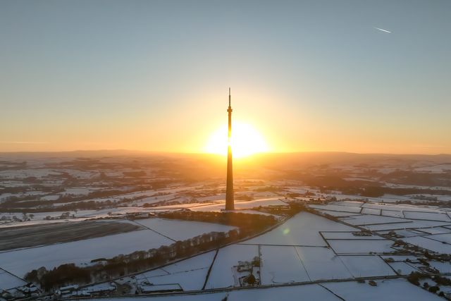 The sun sets over Emley Moor transmitting tower and the snow covered village of Emley as Sub-zero temperatures continue to hamper the north of the United Kingdom; Emley, Huddersfield, United Kingdom, 10th January 2025

(Photo by Mark Cosgrove/News Images)