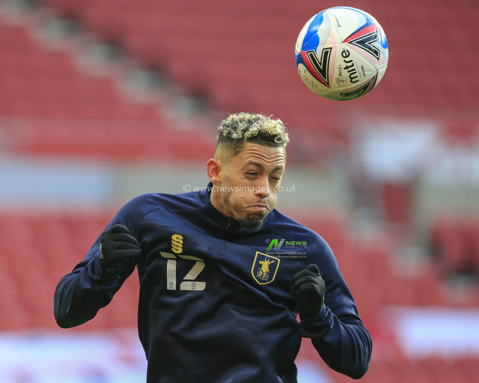 Kellan Gordon #12 of Mansfield Town heads the ball during the pre-game warmup