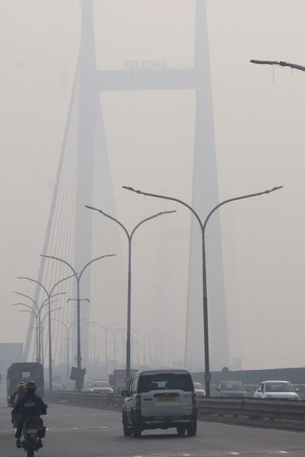 Commuters ride along Vidyasagar Bridge over the Ganga River amid dense fog on a cold winter morning in Howrah,West Bengal,Pictures by Debajyoti Chakraborty.(Photo: Debajyoti Chakraborty/News Images)