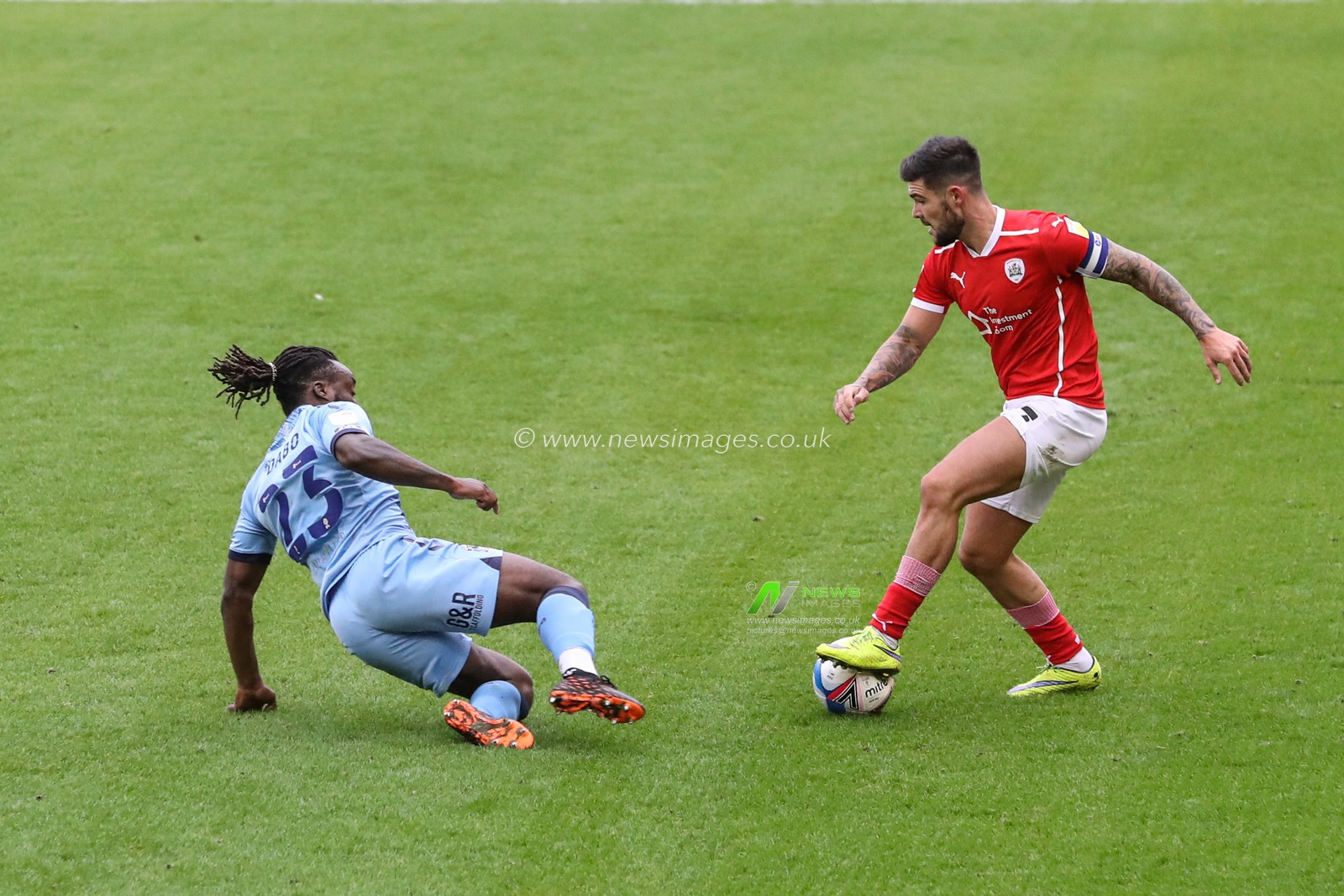 Alex Mowatt (captain) (27) of Barnsley and Fankaty Dabo (23) of Coventry City battle for the ball