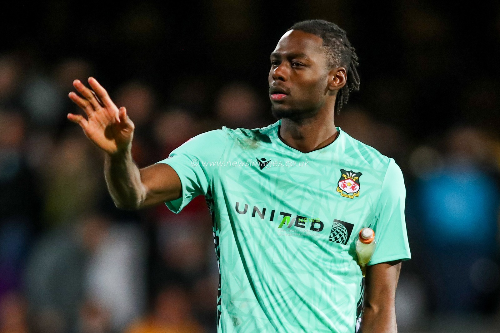 Arthur Okonkwo of Wrexham AFC acknowledges the fans after the teams draw following the Sky Bet League 1 match Cambridge United vs Wrexham at Abbey Stadium, Cambridge, United Kingdom, 1st April 2025

(Photo by Izzy Poles/News Images)