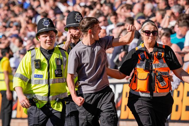 A fan is escorted and ejected from the ground by the police  for attempting to  invade the field of playduring the Premier League match Wolverhampton Wanderers vs Tottenham Hotspur at Molineux, Wolverhampton, United Kingdom on 25 April 2026

(Photo by Maynard Manyowa/News Images)