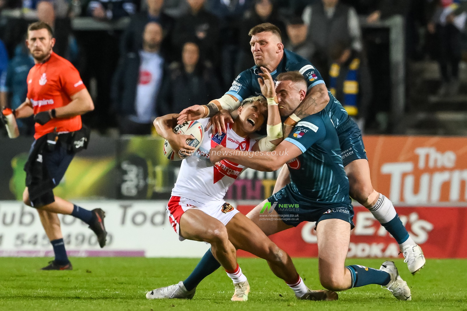 Tee Ritson #25 of St Helens is high tackled by James Harrison #8 and Josh McGuire #13 of Warrington Wolves during the Betfred Super League match St Helens vs Warrington Wolves at Totally Wicked Stadium, St Helens, United Kingdom, 20th April 2023

(Photo by Craig Thomas/News Images)