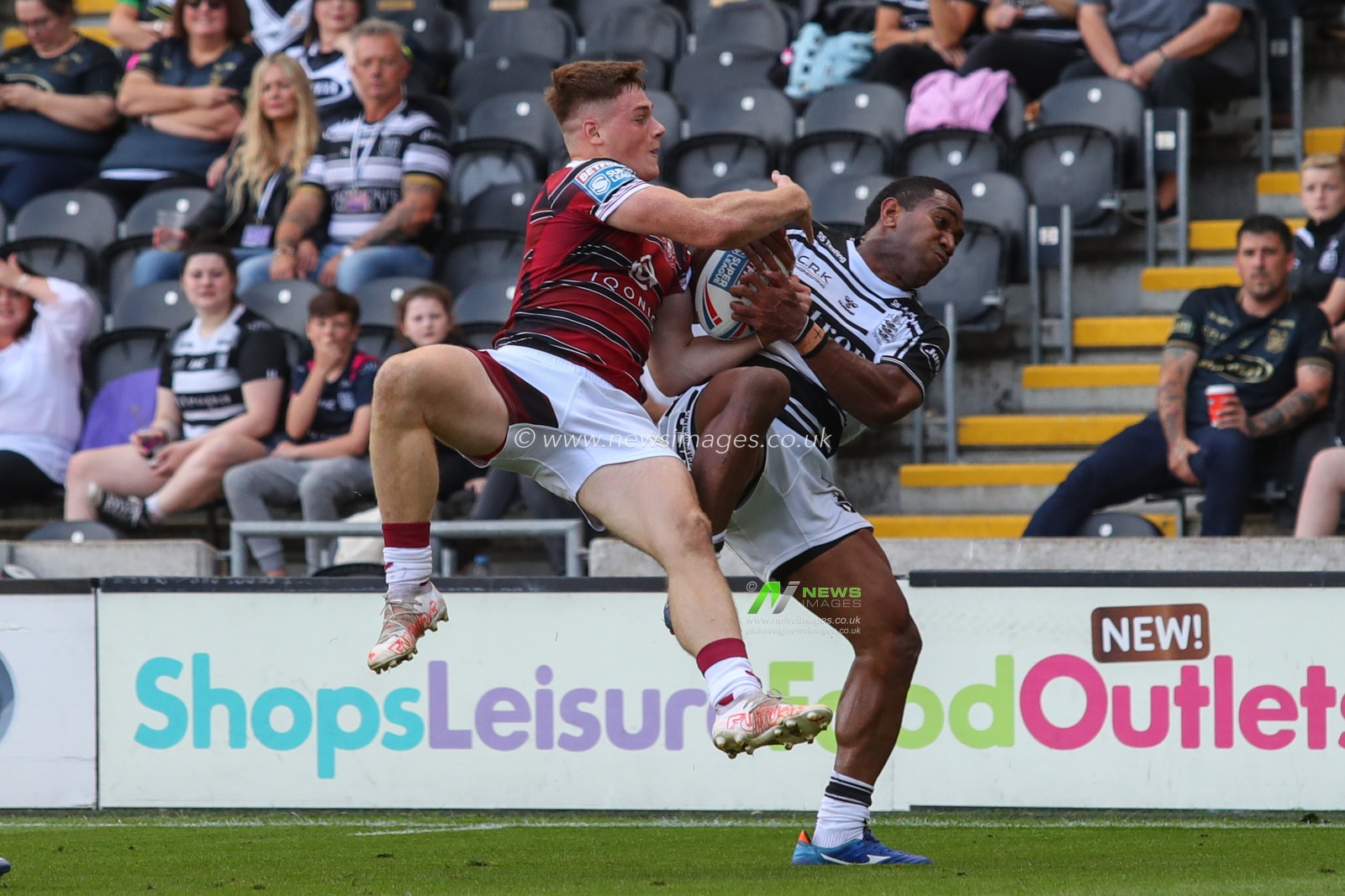 Miteli Vulikijapani #27 for Hull FC and Sam Halsall (28) of Wigan Warriors challenge for the high ball