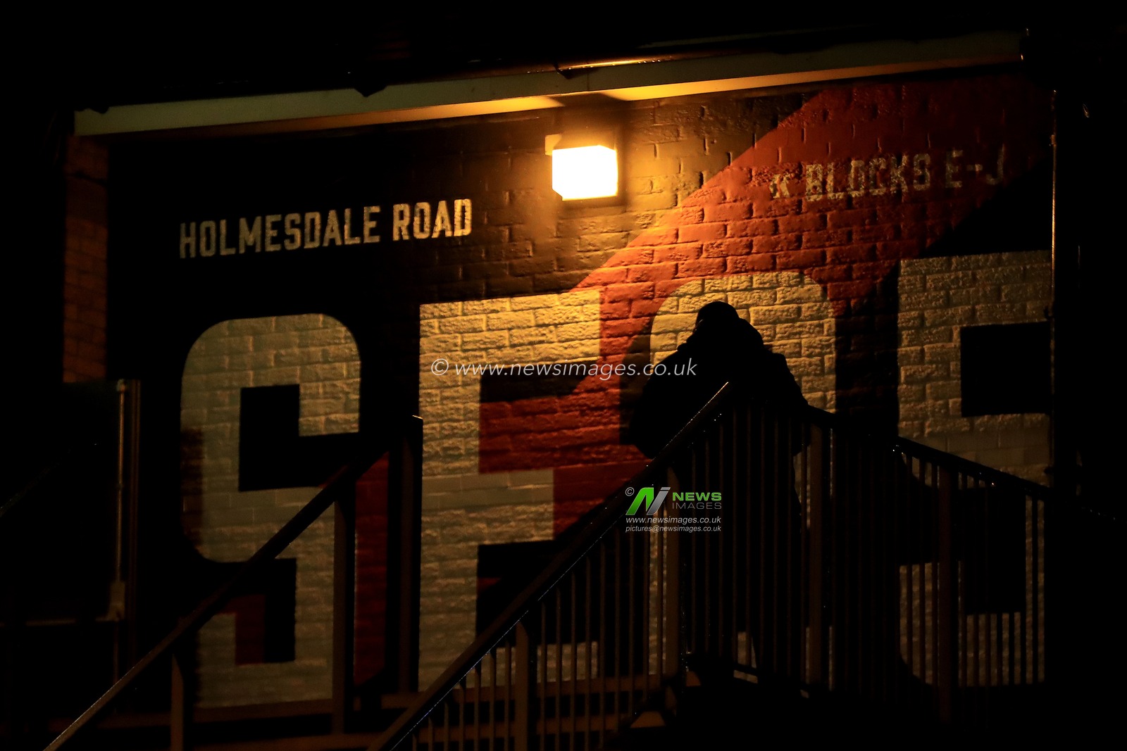 A Crystal Palace fan is silhouetted against the SE25 mural.