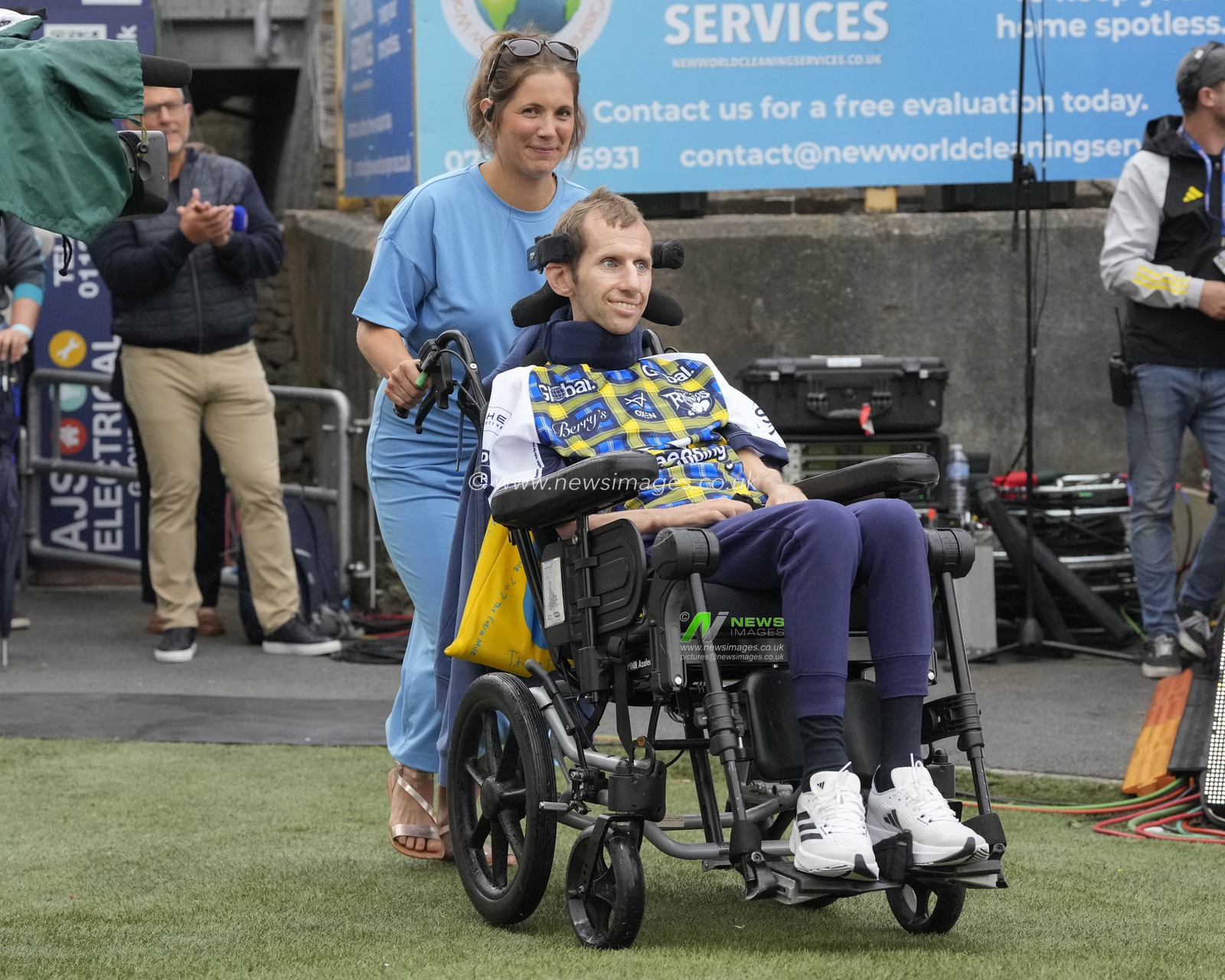 Lindsay Burrow pushes the wheelchair for her husband Rob Burrow onto the pitch before the Motor Neurone Disease Awareness Game, the Betfred Super League Round 16 match Leeds Rhinos vs Huddersfield Giants at Headingley Stadium, Leeds, United Kingdom, 23rd June 2023

(Photo by Steve Flynn/News Images)