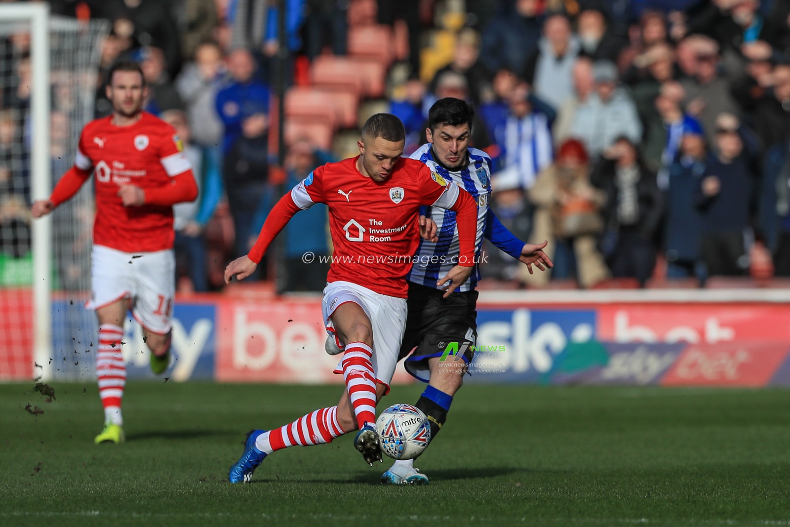 Jordan Williams (2) of Barnsley plays the ball as Fernando Forestieri (45) of Sheffield Wednesday tracks him