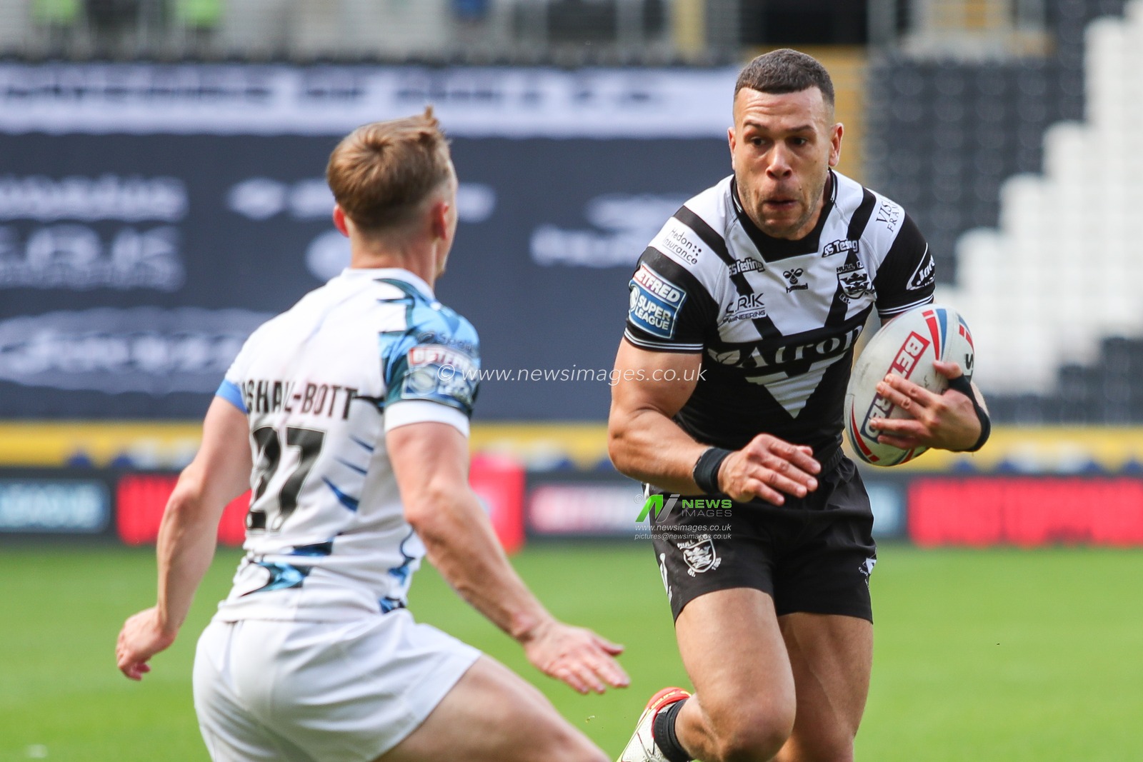 Carlos Tuimavave #3 of Hull FC runs at Olly Ashall-Bott #27 of Toulouse Olympique
