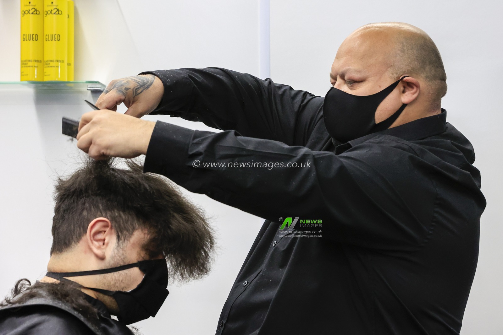 Tommy cuts a customer's hair at Henry's Barbershop, High Bridge, Newcastle upon Tyne, as national lockdown restrictions are eased in England