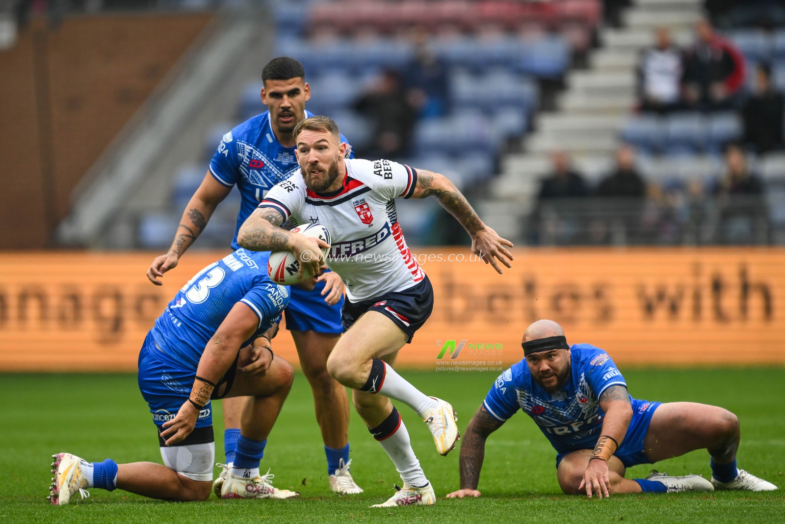Daryl Clark of England breaks the tackle of Jeremiah Nanai and Jazz Tevaga of Samoa  during the ABK Beer Internationals Series match England vs Samoa at The Brick Community Stadium, Wigan, United Kingdom, 27th October 2024

(Photo by Craig Thomas/News Images)