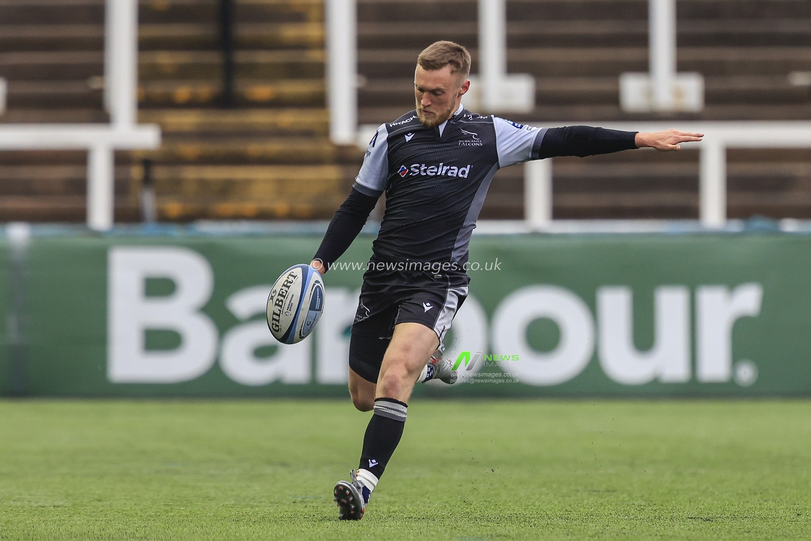 Brett Connon of Newcastle Falcons kicks the ball forward