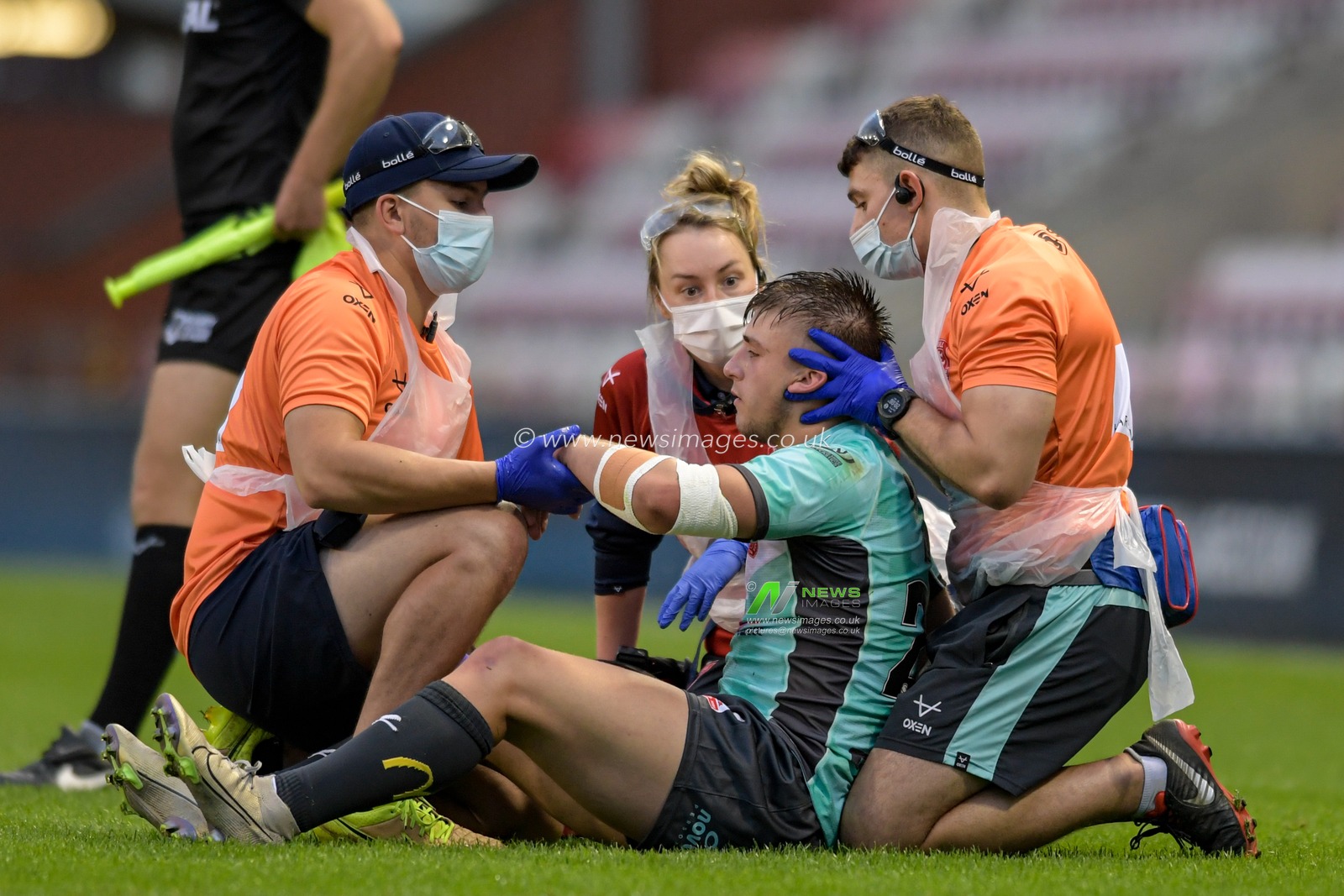 Mikey Lewis (20) of Hull KR receives treatment on the pitch after an injury