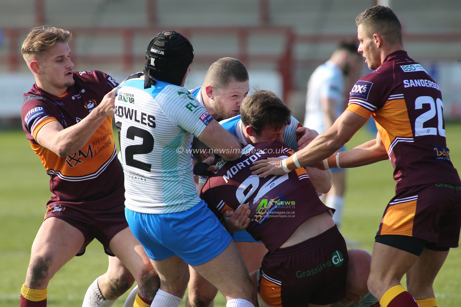 Dale Morton of Batley Bulldogs wrapped in tackle by Michael Knowles and Sam Day of Dewsbury Rams