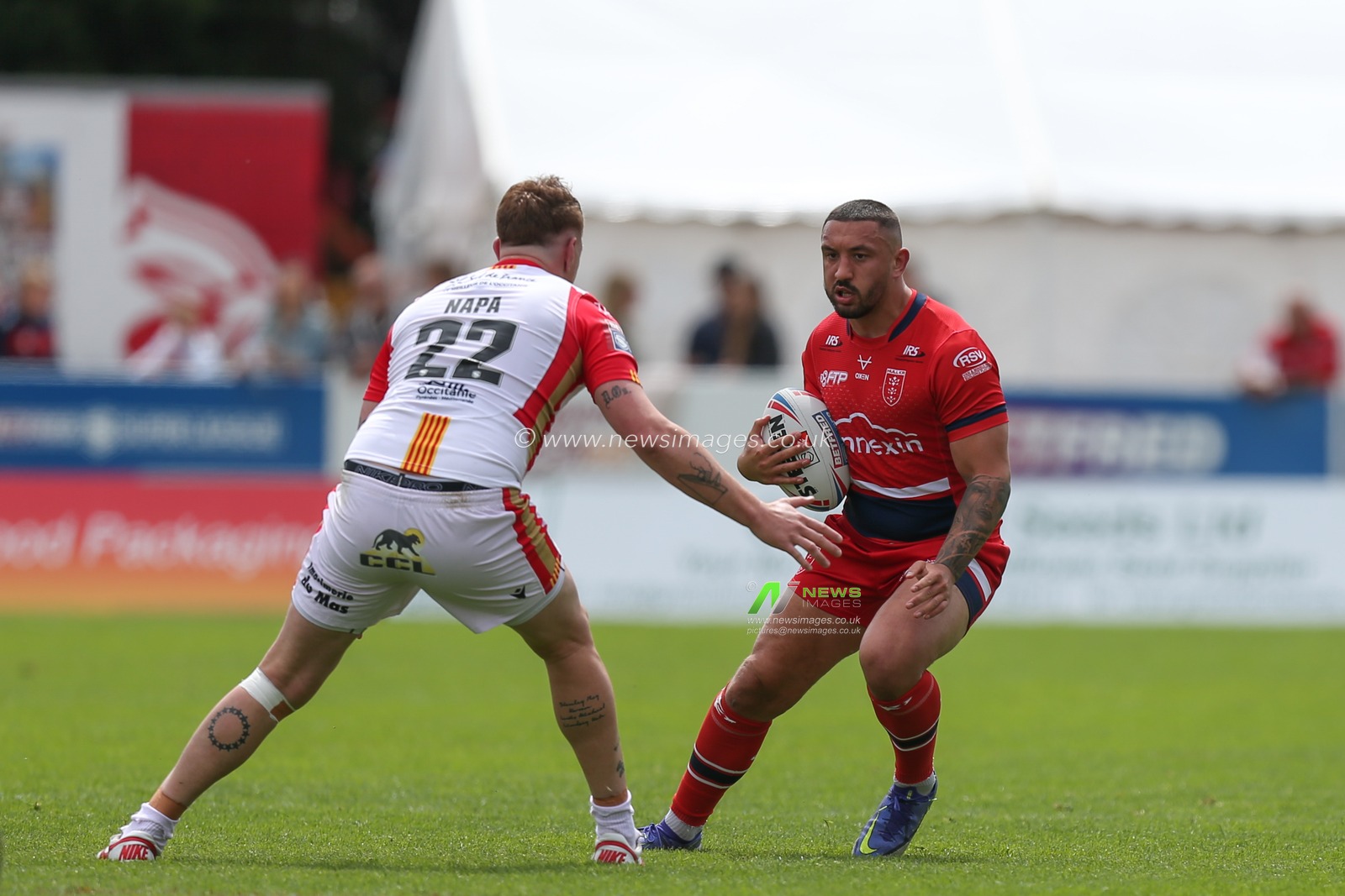 Elliot Minchella #17 of Hull KR runs at Dylan Napa #22 of Catalans Dragons