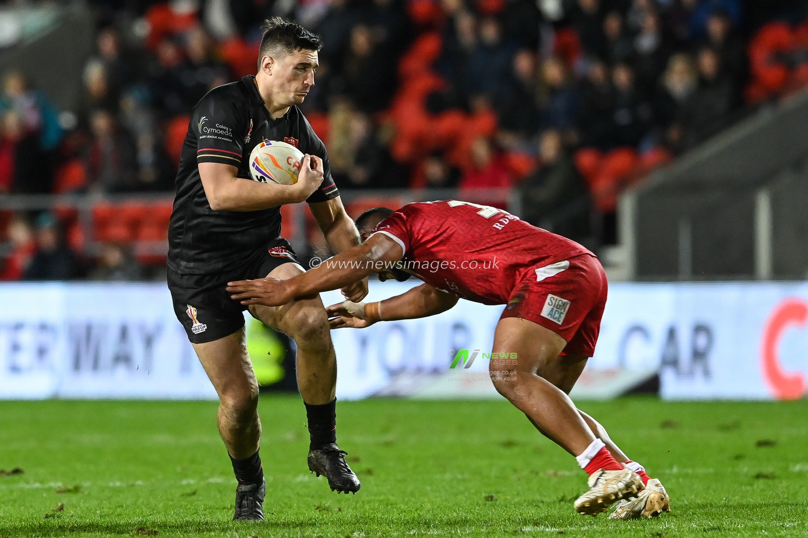 Joe Burke of Wales is tackled by Moeaki Fotuaika of Tonga  during the Rugby League World Cup 2021 match Tonga vs Wales at Totally Wicked Stadium, St Helens, United Kingdom, 24th October 2022

(Photo by Craig Thomas/News Images)