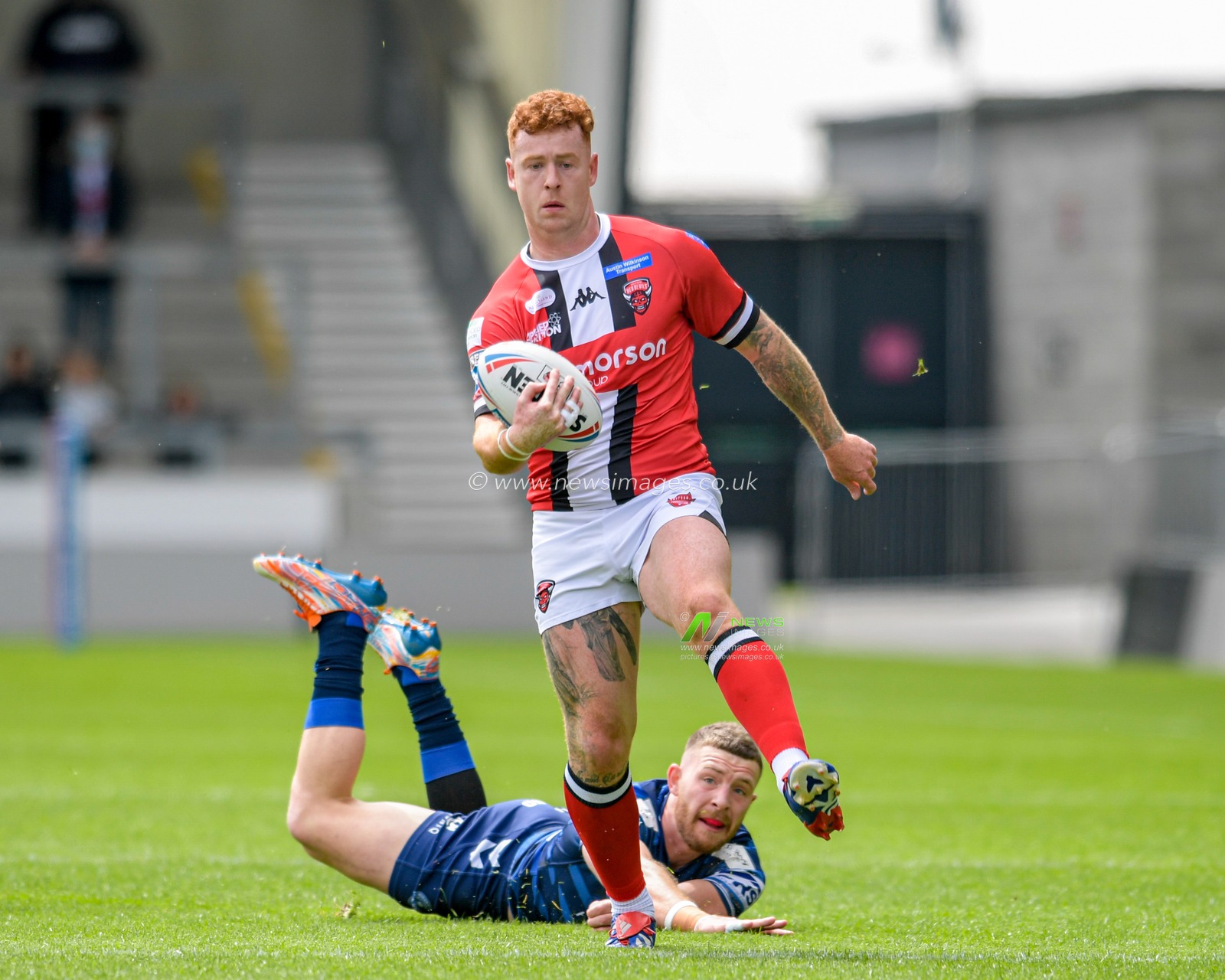 Jackson Hastings (31) of Wigan Warriors fails in his attempt to tackle Harvey Livett (20) of Salford Red Devils