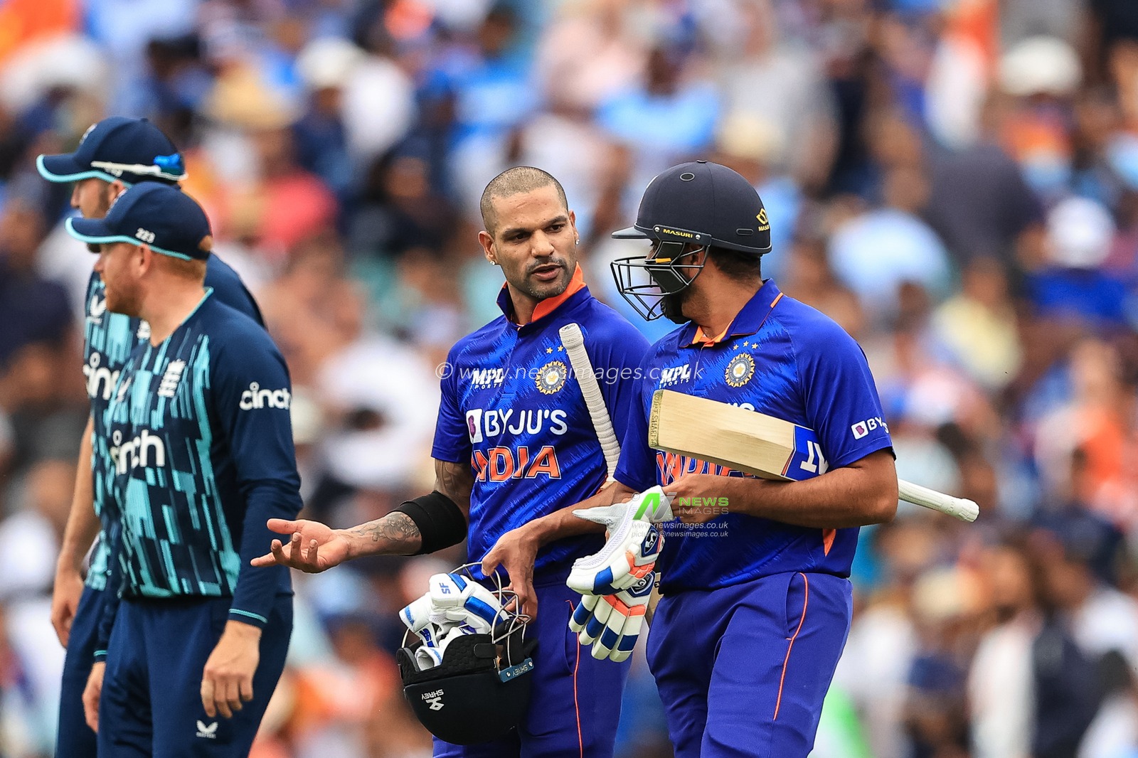 Shikhar Dhawan of India and Rohit Sharma of India chat as they leave the field of play victorious after India beat England by 10 wickets