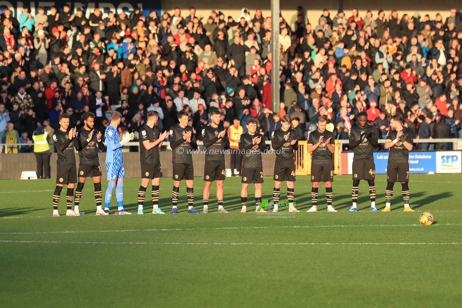 The fans and players have a minute applaud for a fan who lost their life last season during the Sky Bet League 1 match Lincoln City vs Barnsley at Gelder Group Sincil Bank Stadium, Lincoln, United Kingdom, 25th November 2023

(Photo by Alfie Cosgrove/News Images)