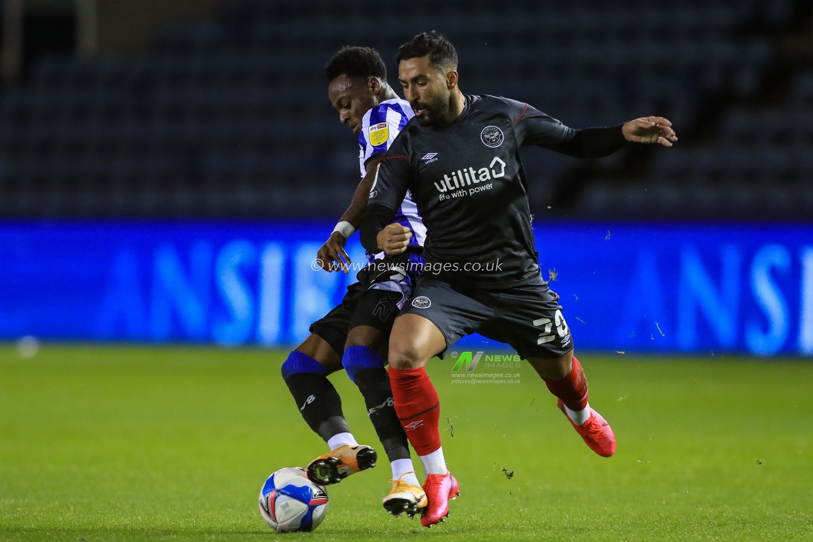 Moses Odubajo (22) of Sheffield Wednesday tackled Saman Ghoddos (20) of Brentford