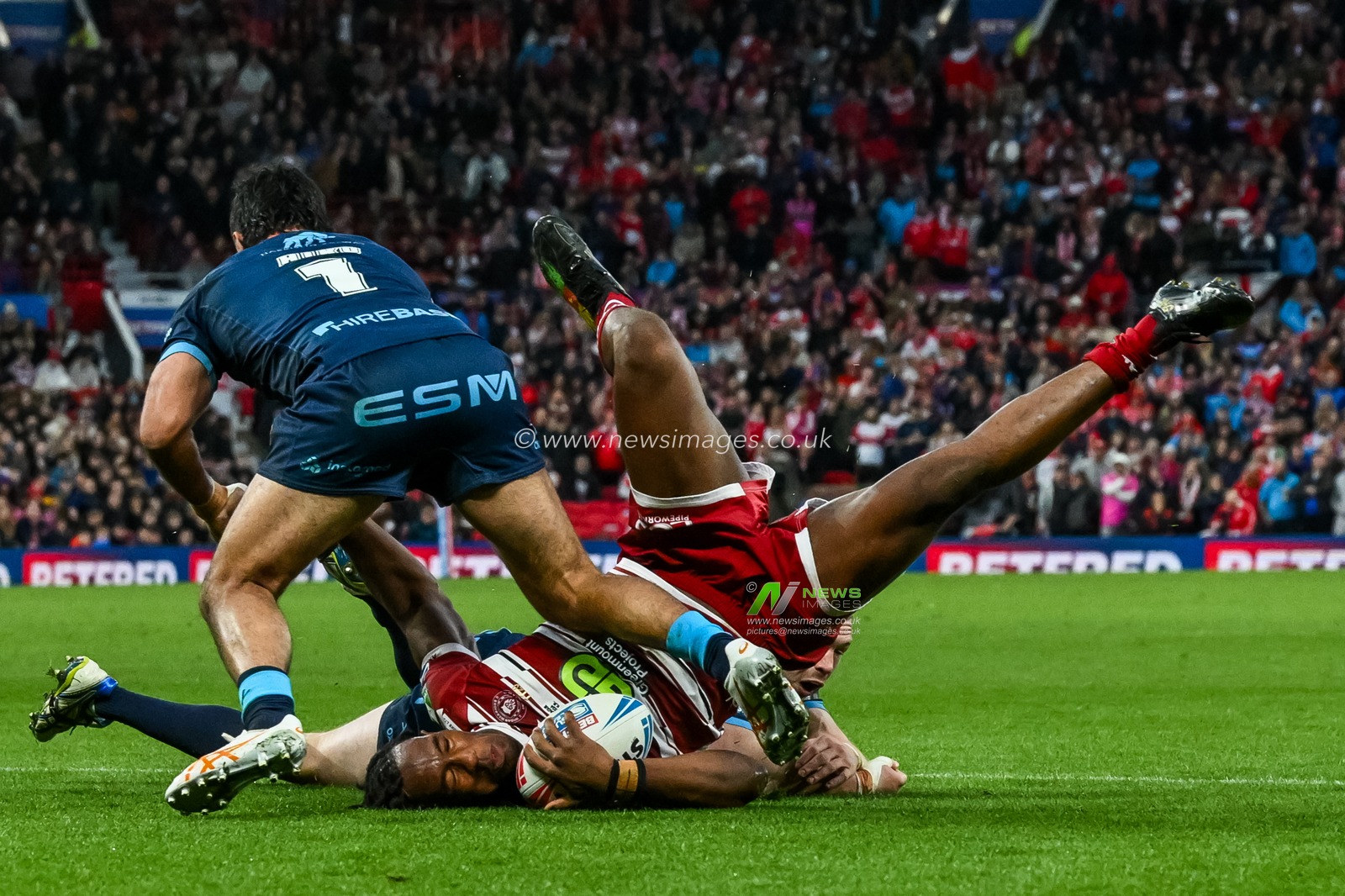 Junior Nsemba of Wigan Warriors is tackled by James Batchelor and Peta Hiku of Hull KR during the Betfred Super League Grand Final match Wigan Warriors vs Hull KR at Old Trafford, Manchester, United Kingdom, 12th October 2024

(Photo by Craig Thomas/News Images)