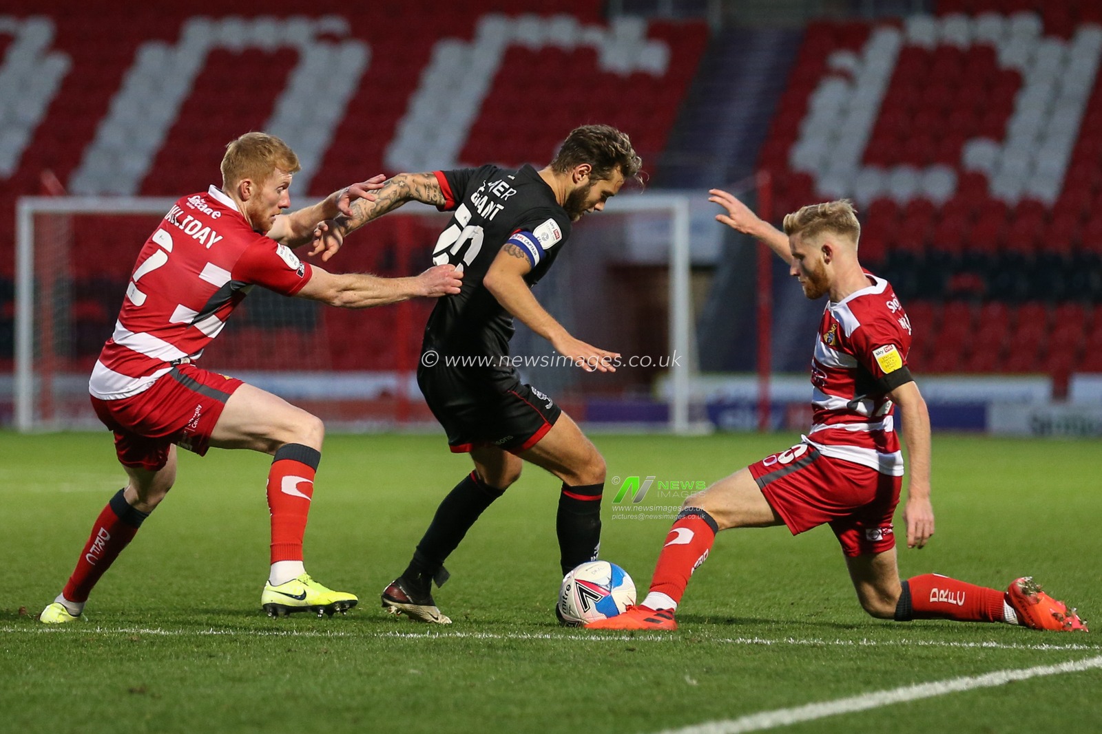 Jorge Grant (10) of Lincoln City battles for possession with Josh Sims (20) of Doncaster Rovers
