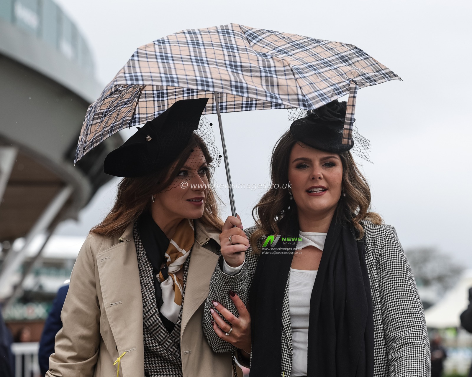 Racegoers coverup under a brolly as rain bings to pour during the 2026 Randox Grand National Opening Day at Aintree Racecourse, Aintree, United Kingdom on 09 April 2026

(Photo by Mark Cosgrove/News Images)