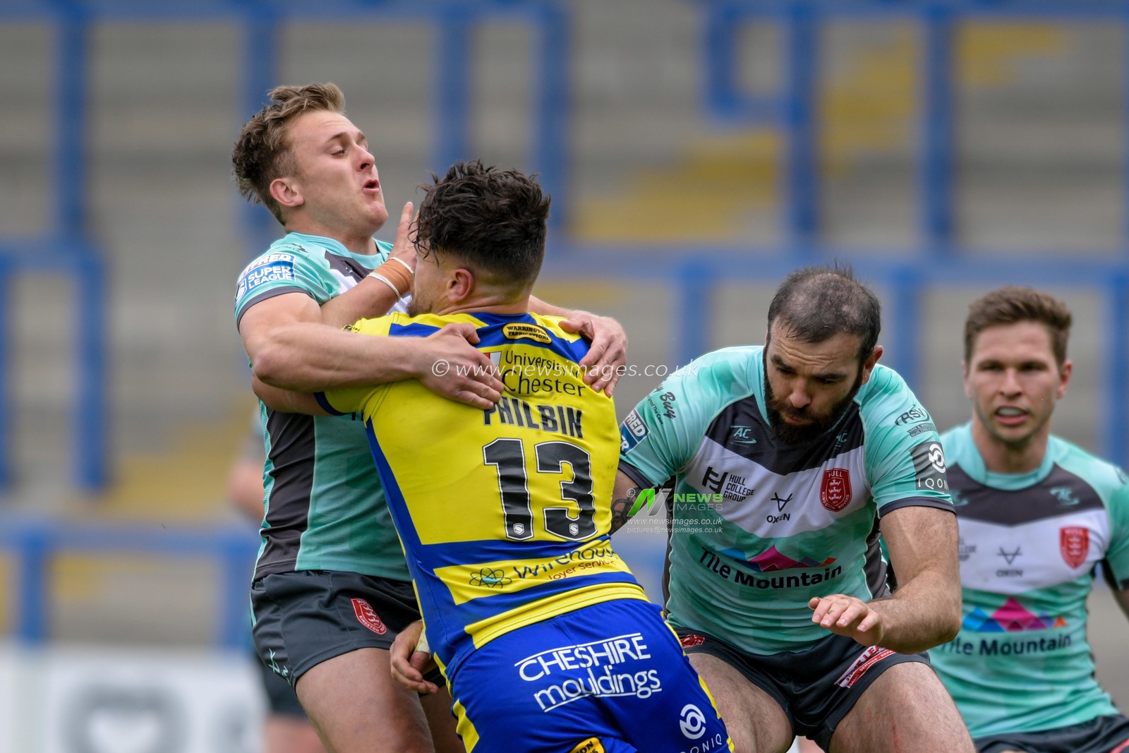 Joe Philbin (13) of Warrington Wolves is tackled by Jez Litten (14) of Hull KR and Kane Linnett (12) of Hull KR