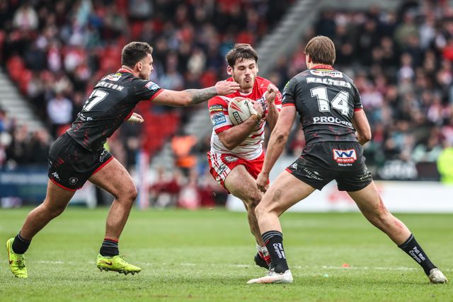 Noah Stephens of St Helens is tackled by Oliver Partington of Wigan Warriors and Sam Walters of Wigan Warriors during the Betfred Super League round 7 match St Helens vs Wigan Warriors at The BrewDog Stadium, St Helens, United Kingdom on 03 April 2026

(Photo by Alfie Cosgrove/News Images)