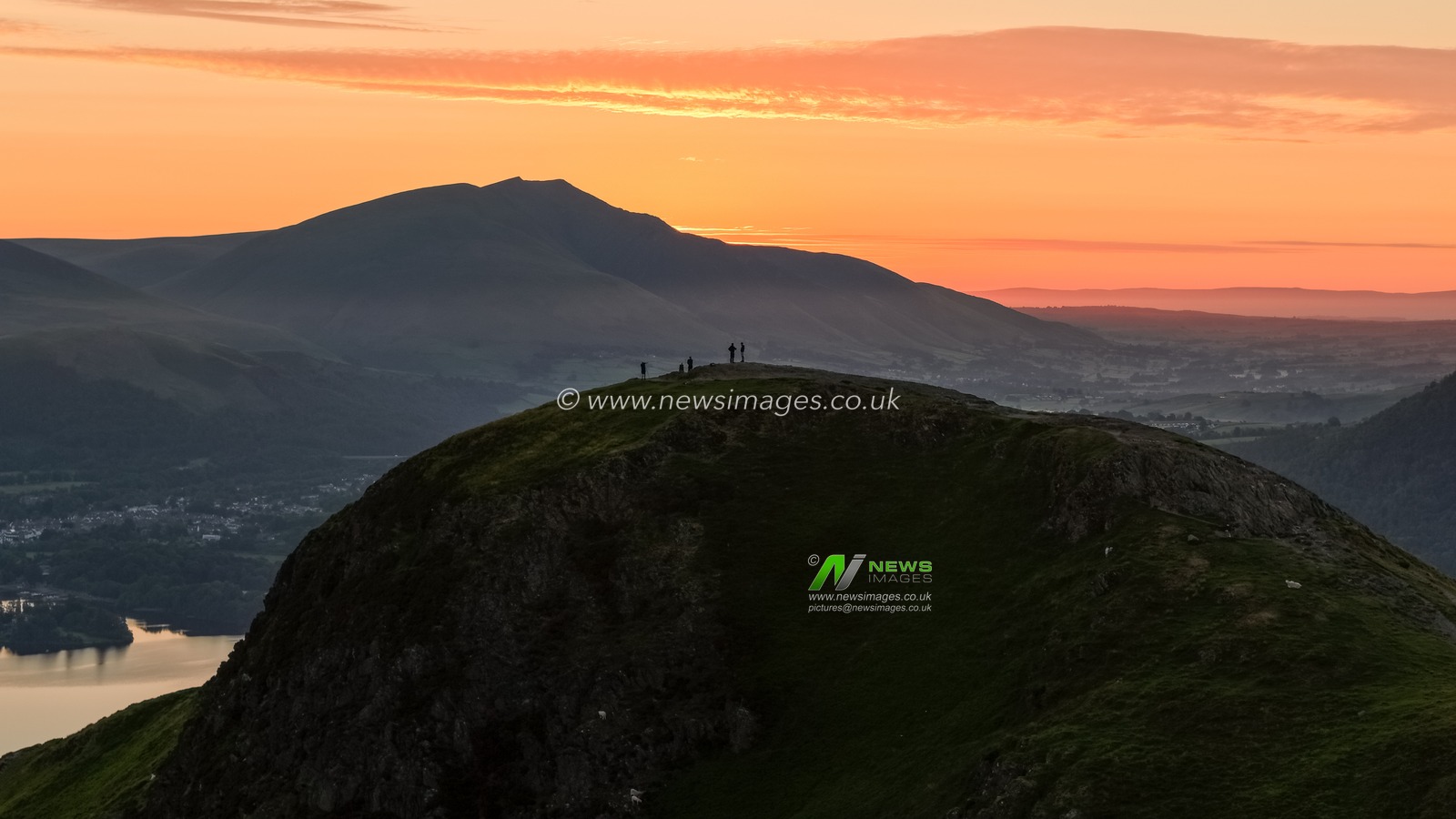 Photographers take pictures as the sun rises from the summit of Catbells overlooking Derwent Water and the town of Keswick In the Lake District, Cumbria, United Kingdom, 19th June 2025.

(Photo by Mark Cosgrove/News Images)