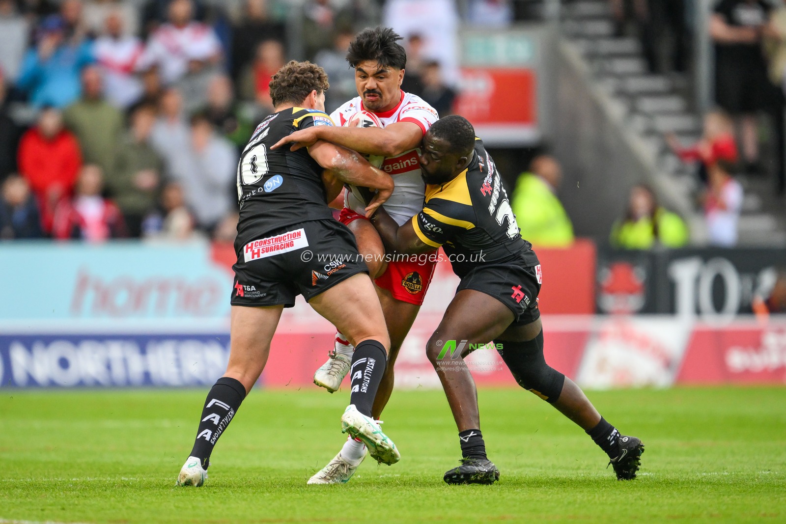 James Bell of St. Helens is tackled by Muizz Mustapha of Castleford Tigers and George Lawler of Castleford Tigers during the Betfred Super League Round 16 match St Helens vs Castleford Tigers at Totally Wicked Stadium, St Helens, United Kingdom, 5th July 2024

(Photo by Craig Thomas/News Images)