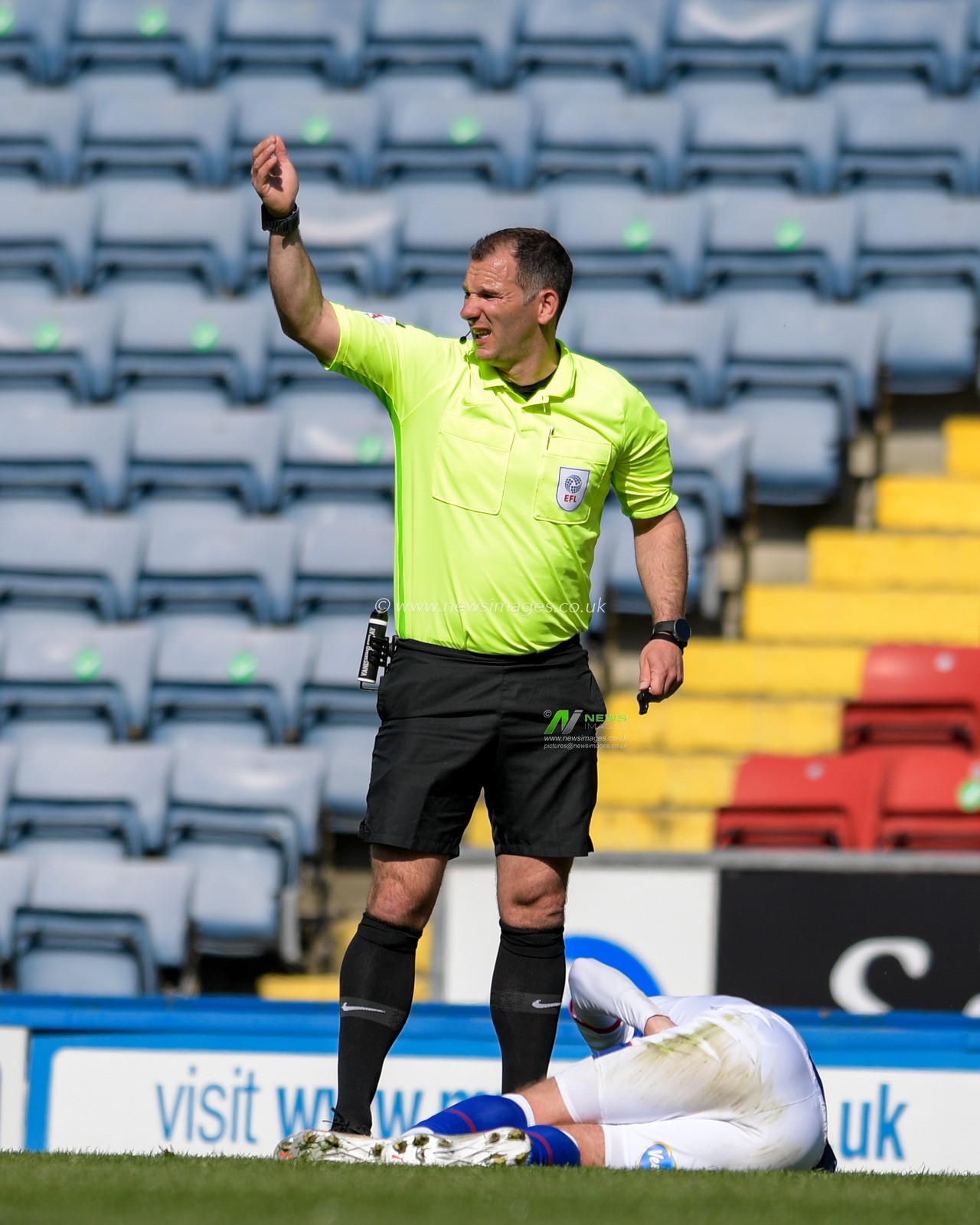 Referee Tim Robinson calls for the Blackburn medical team after Joe Rothwell #8 of Blackburn Rovers lies injured on the pitch