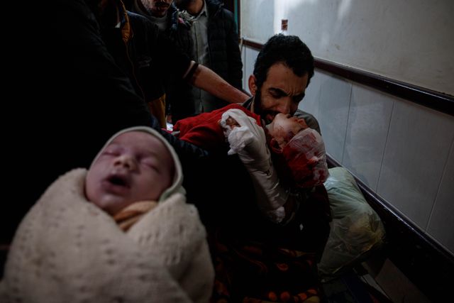 An injured father bids farewell to his son and daughter at Al-Aqsa Martyrs Hospital, who were killed in an Israeli bombing that targeted their home in Deir al-Balah this morning, in addition to their mother who was killed in the same attack.(Photo: Mohammed Skaik/News Images)