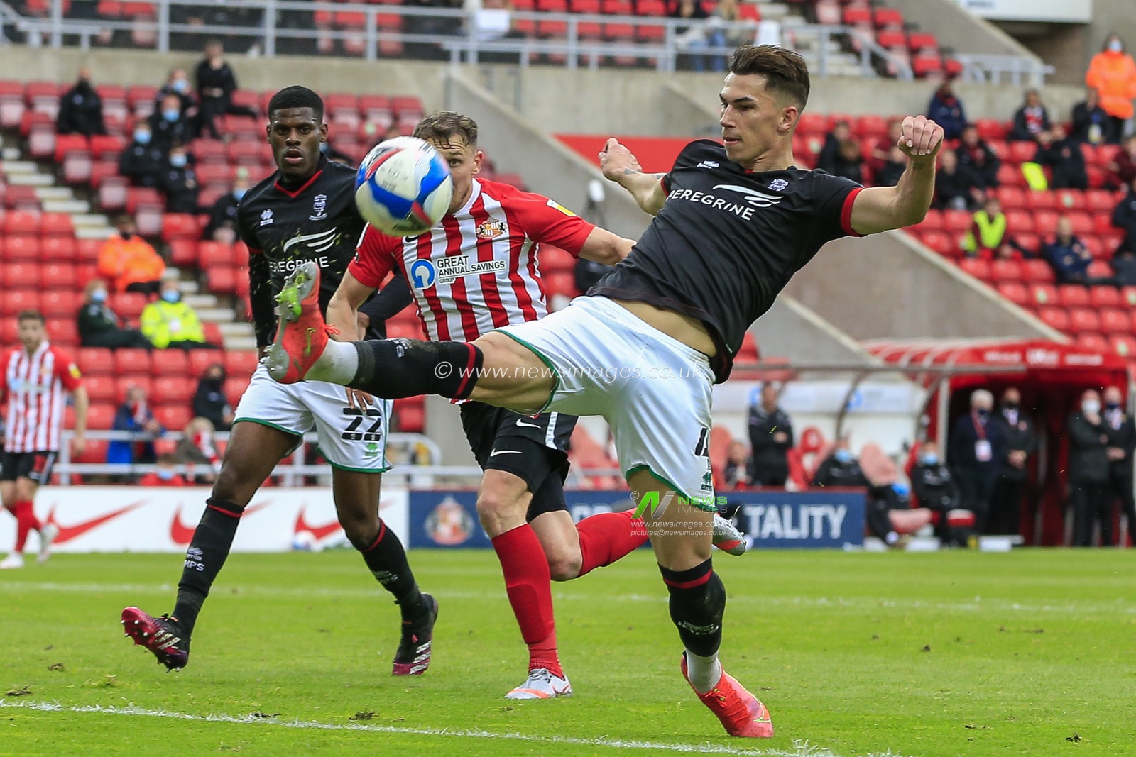 Lewis Montsma #4 of Lincoln City clears the ball away under pressure from Charlie Wyke #9 of Sunderland