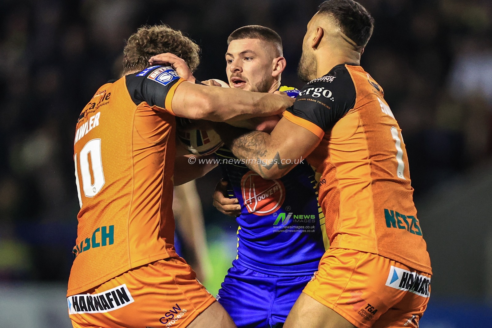 Danny Walker #16 of Warrington Wolves is tackled by George Lawler #10 of Castleford Tigers and Kenny Edwards #11 of Castleford Tigers