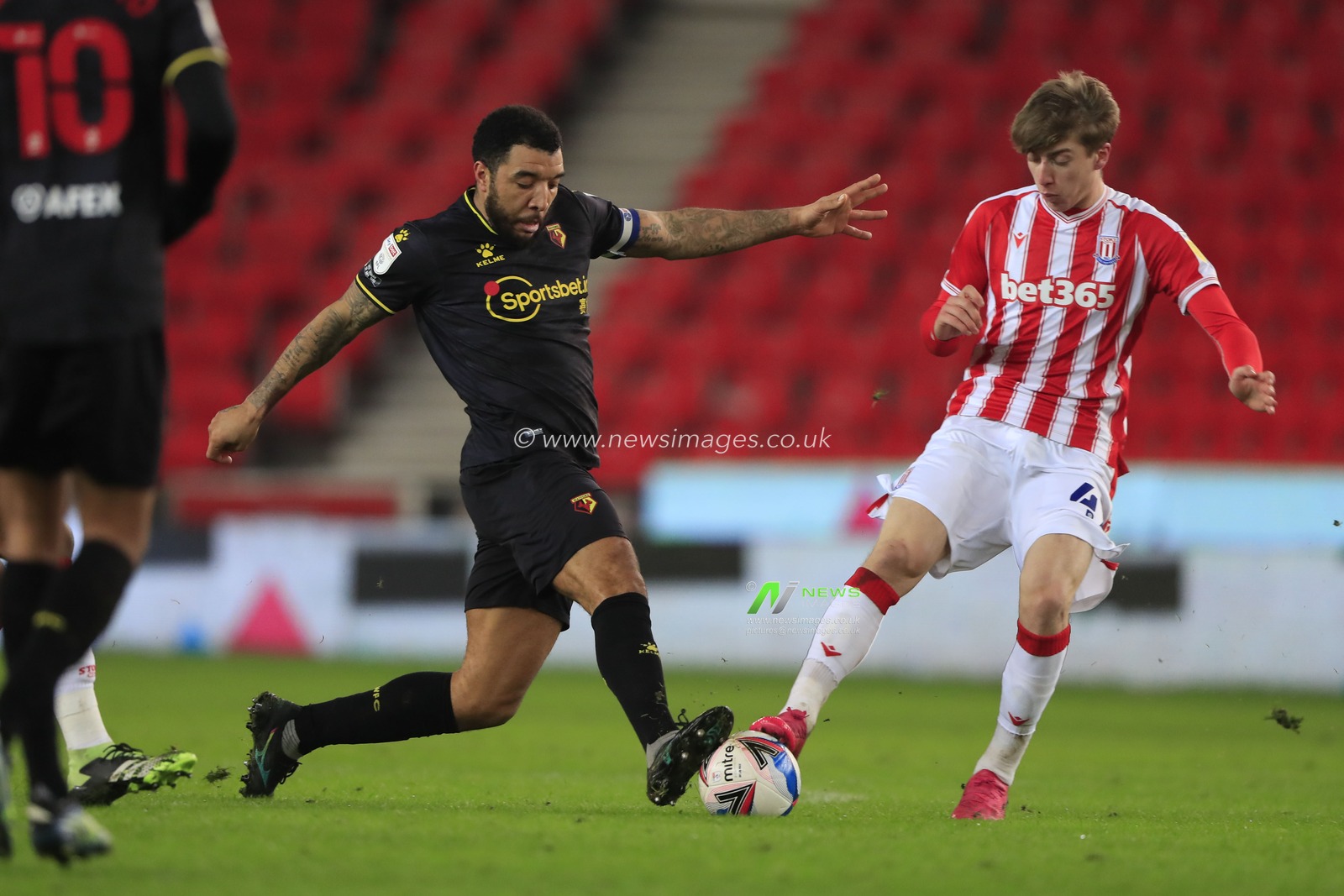 Troy Deeney #9 of Watford and Jack Clarke #47 of Stoke City challenge for the ball
