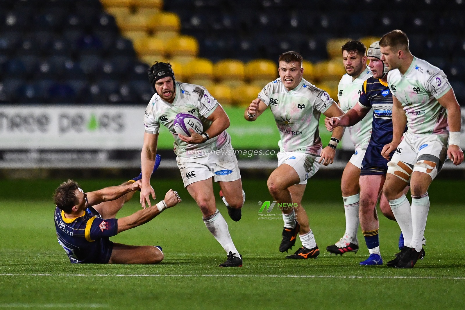 Dan Evans of Ospreys evades the tackle of Ashley Beck of Worcester Warriors
