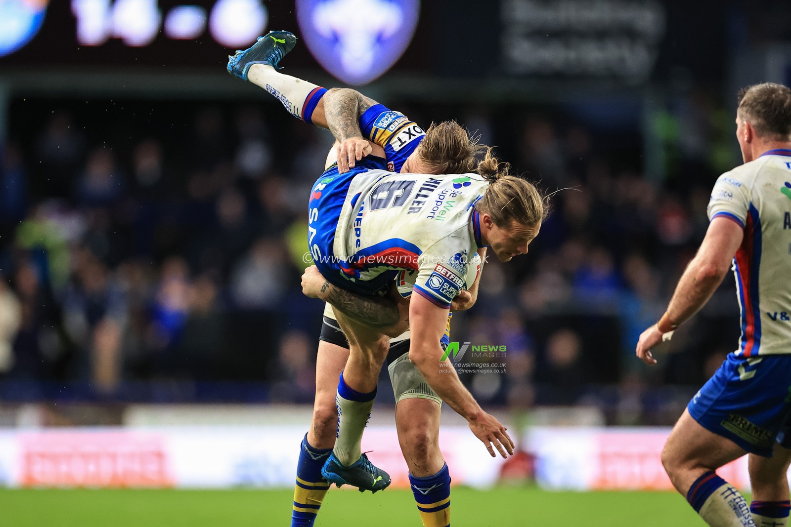 Jacob Miller #6 of Wakefield Trinity is is tackled by Blake Austin of Leeds Rhinos